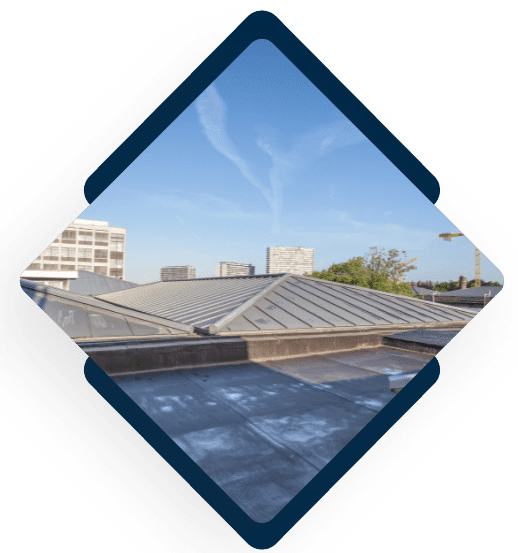 Modern metal roofing installation on commercial building with city skyline view