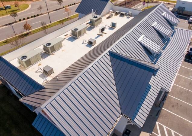 Aerial view of a modern metal roof on a commercial building with HVAC units.