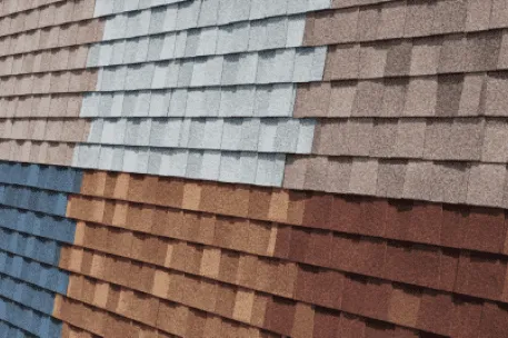 Colorful asphalt roof shingles display in multiple rows showing gray, brown, blue and red samples
