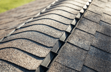 Close-up view of asphalt roof shingles with ridge vent installation detail